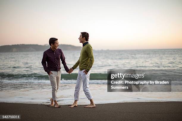 gay couple on san francisco beach. - asian man barefoot foto e immagini stock