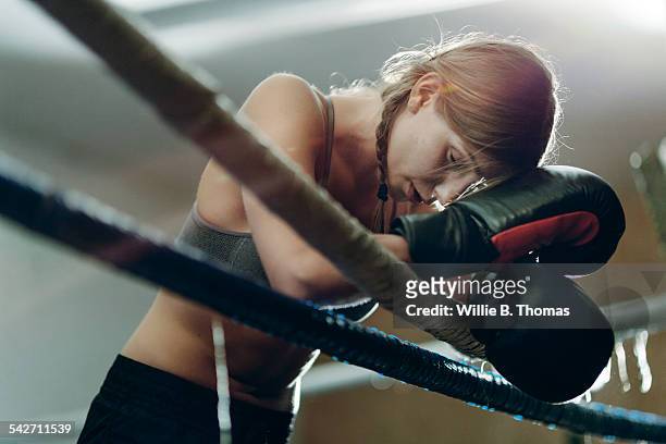 fatigued boxer leaning ropes - boxen sport stock-fotos und bilder