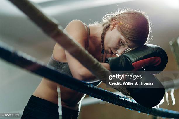 fatigued boxer leaning ropes - boxning sport photos et images de collection