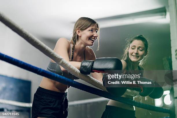 two female fighters leaning on ropes - boxeo deporte fotografías e imágenes de stock