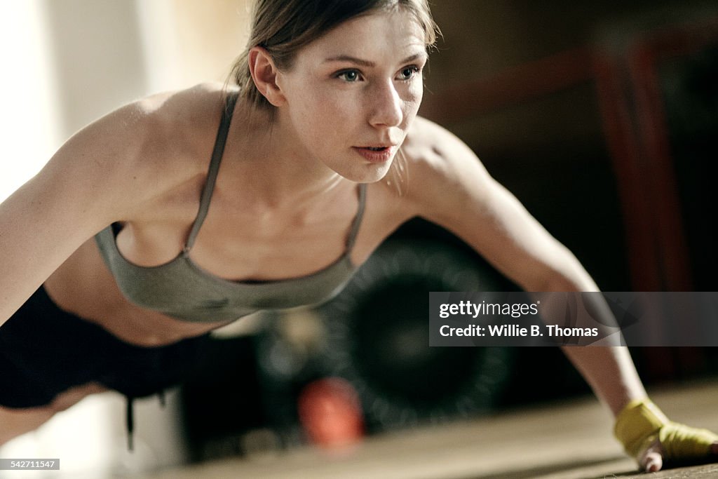 Focused female boxer doing push-ups