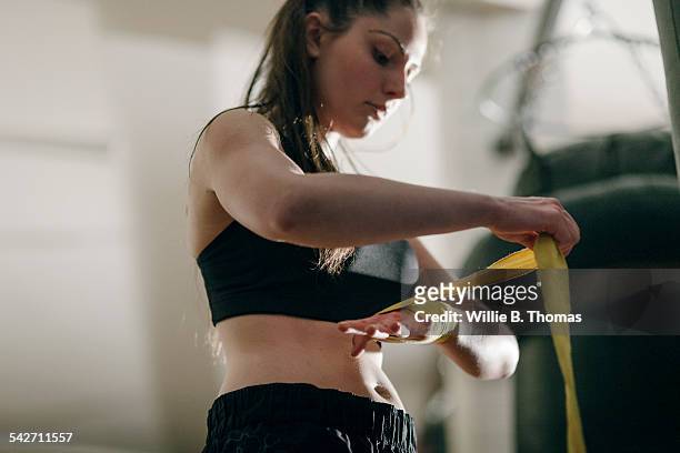 female boxer wrapping her hands in gym - making stock-fotos und bilder