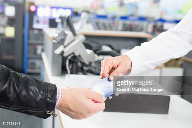 handing over a credit card - elektromarkt foto e immagini stock