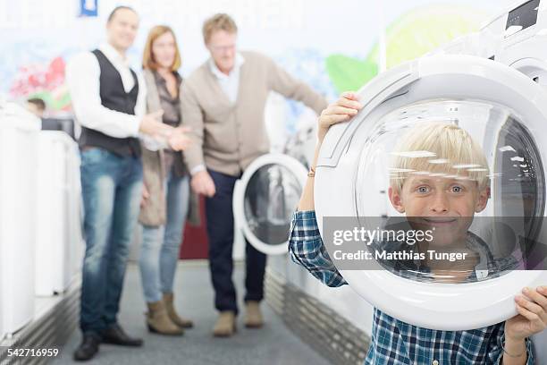 little boy playing with a washing machine - elektromarkt foto e immagini stock