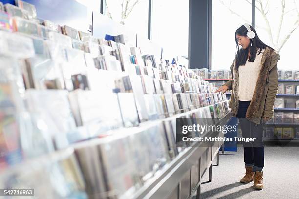 young girl looking for some new music cd's - elektromarkt foto e immagini stock