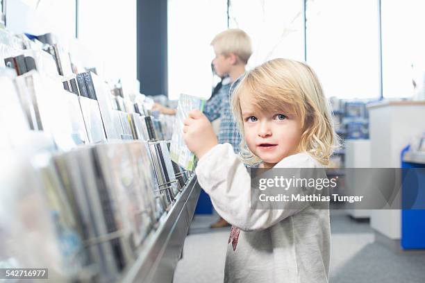 children searching new dvd's in an electric shop - elektromarkt foto e immagini stock