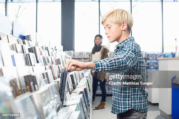 littel boy looking for a new dvd - elektromarkt foto e immagini stock