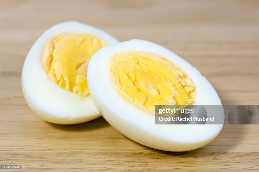 Hard boiled egg cut in half on chopping board