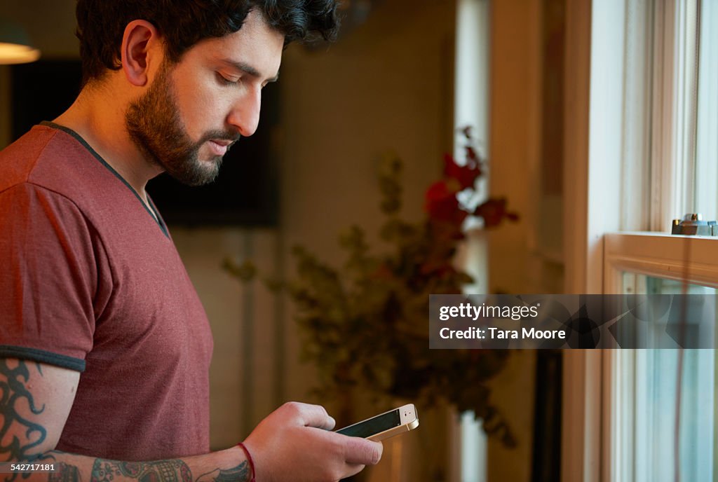 Young man using mobile at home