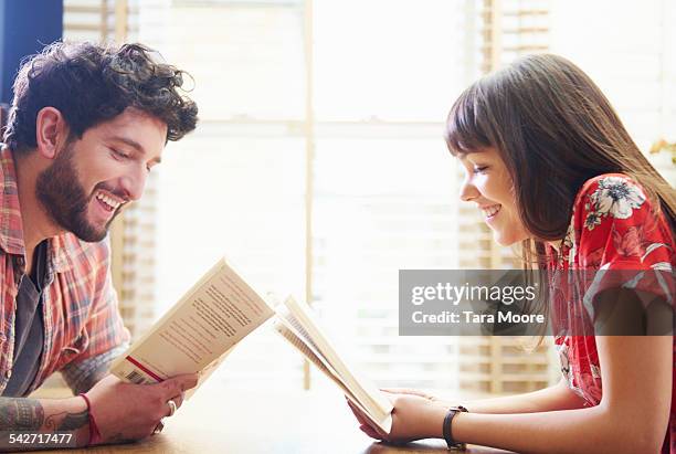 young man and woman reading books at home - reading england stock-fotos und bilder