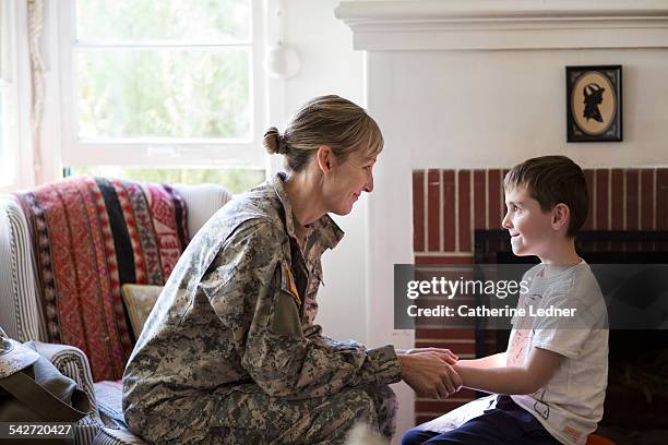 military mom at home with son - man and woman holding hands profile stock-fotos und bilder