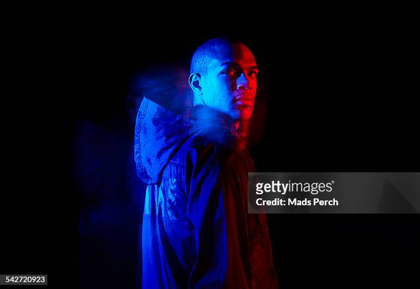 young man photographed with creative lighting - rood jak stockfoto's en -beelden