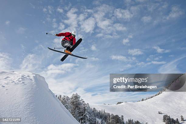 a skier crossing up as he jumps into powder - big air stock-fotos und bilder
