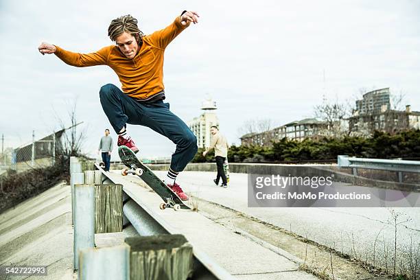 young men skateboarding in urban environment. - skateboard foto e immagini stock