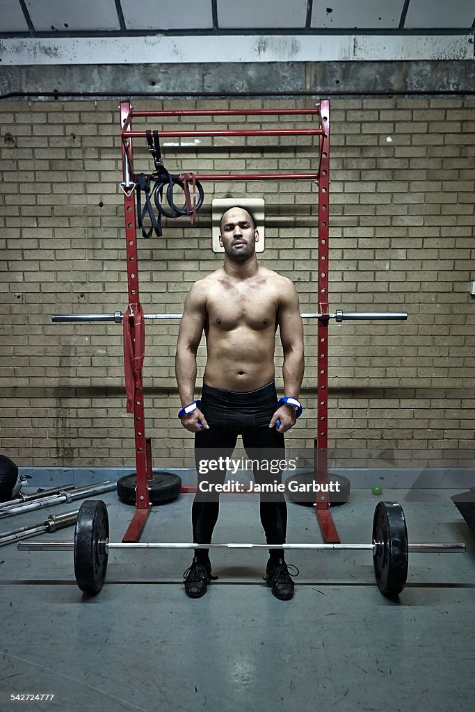 Mixed race weight lifter standing in the gym