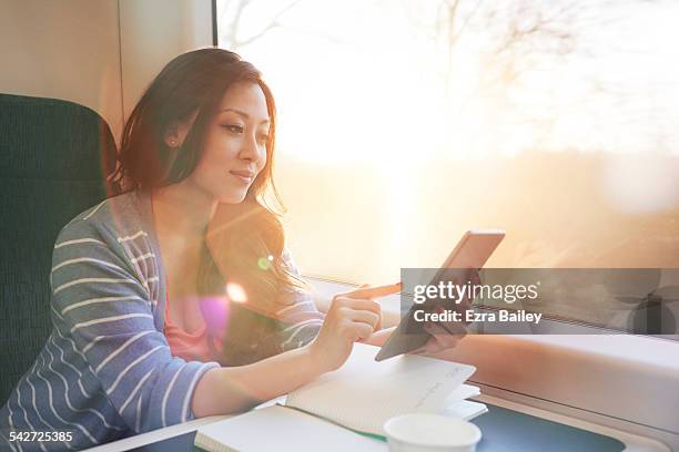woman on a train working on a tablet. - tåginteriör bildbanksfoton och bilder