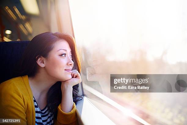 woman on a train day dreaming out the window. - woman day dreaming fotografías e imágenes de stock