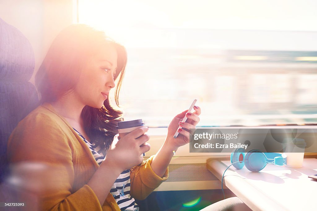 Woman on a commuter train looking at her phone.