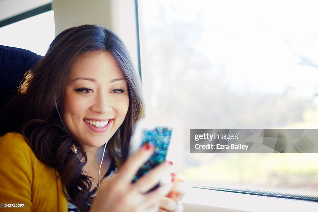 Woman on a train looking at her phone.