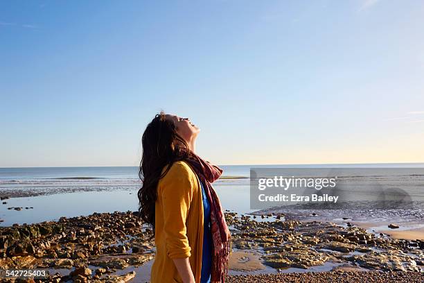woman on the beach breathing in the fresh air - cardigan photos et images de collection