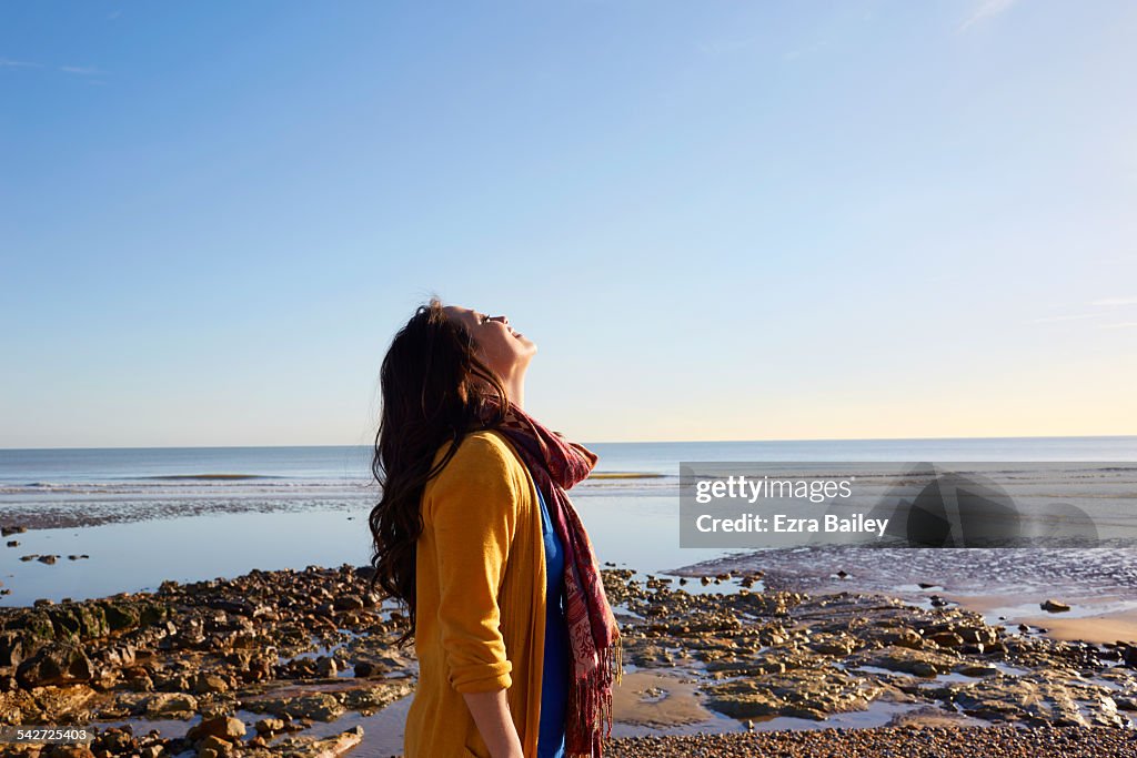 Woman on the beach breathing in the fresh air