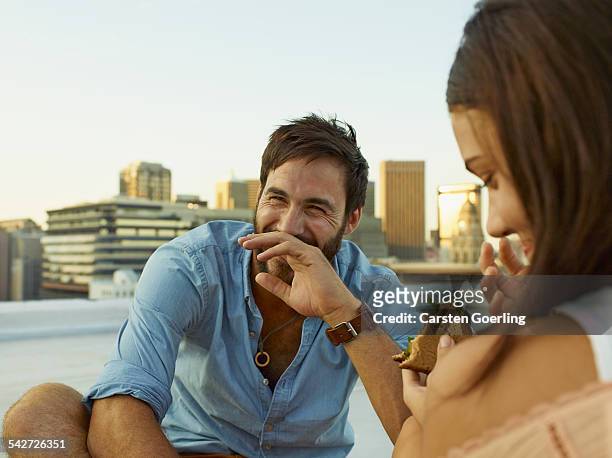 couple on a rooftop - man eating woman out stockfoto's en -beelden