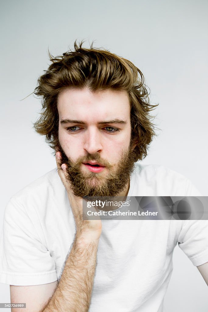 Portrait of man rubbing beard