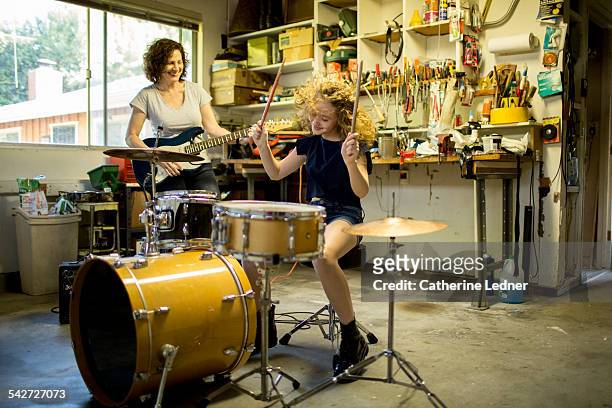 mom and daughter garage band - drums stock-fotos und bilder