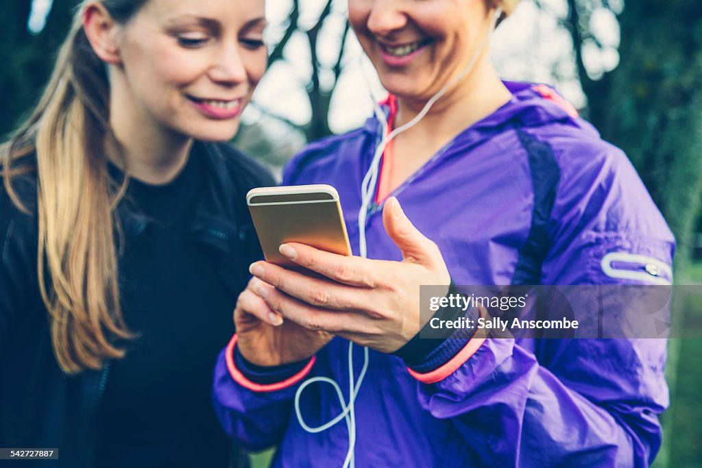 Two female runners using a smart phone