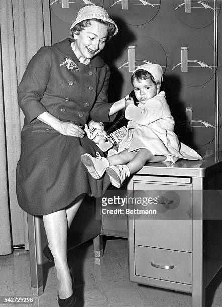 Actress Olivia de Havilland and her 2-year-old daughter, Gisele, are shown on arrival at Idlewild airport. Olivia is here to start a tour for "Proud...