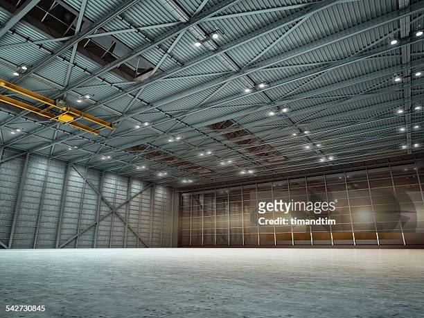 empty hangar by night with lights on - airplane hangar stock pictures, royalty-free photos & images