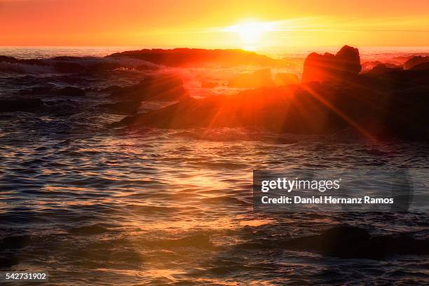 a guarda. waves crashing at sunset with the sun setting in the background - guarda sol stock pictures, royalty-free photos & images