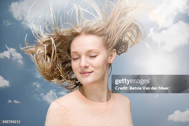 young woman shaking her hair in wind - cheveux au vent photos et images de collection