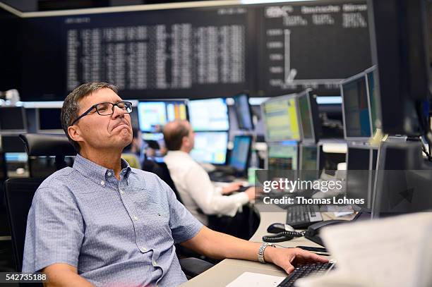 Trader looks to his computer screens whilst working at the Frankfurt Stock exchange the day after a majority of the British public voted for leaving...