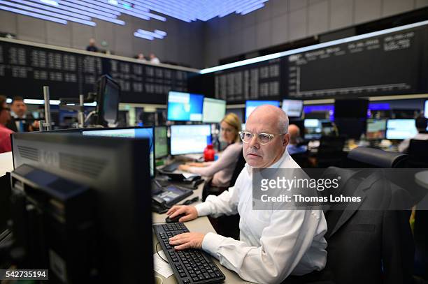 Trader looks to his computer screens whilst working at the Frankfurt Stock exchange the day after a majority of the British public voted for leaving...