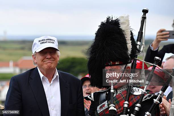 Bagpipe player wears traditional dress next to Presumptive Republican nominee for US president Donald Trump as he arrives to his Trump Turnberry...