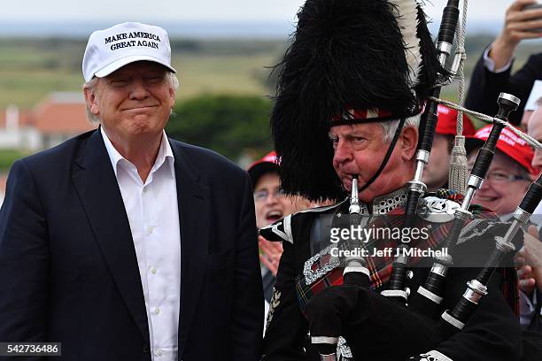 Bagpipe player wears traditional dress next to Presumptive Republican nominee for US president Donald Trump as he arrives to his Trump Turnberry...