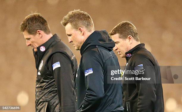 Nathan Buckley, coach of the Magpies along assistant coaches Scott Burns and Ben Hart look on during the round 14 AFL match between the Collingwood...