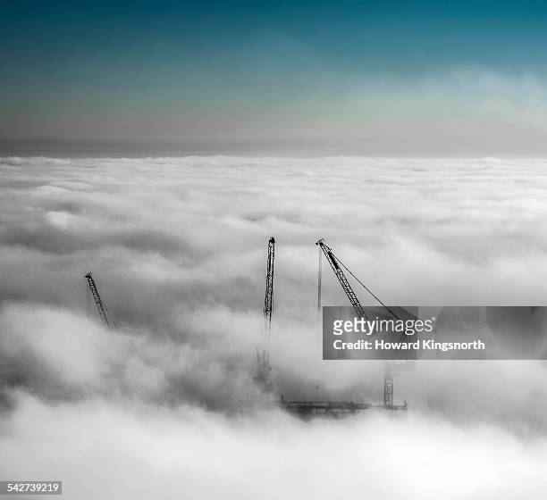 cranes and clouds - mystery machine stock pictures, royalty-free photos & images