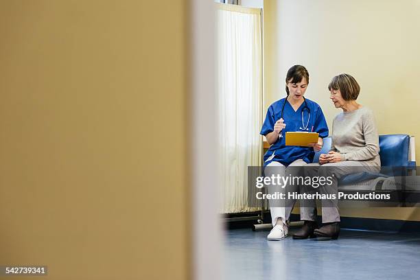 female doctor help senior patient with paperwork - doctor stethoscope patient whole body stock pictures, royalty-free photos & images