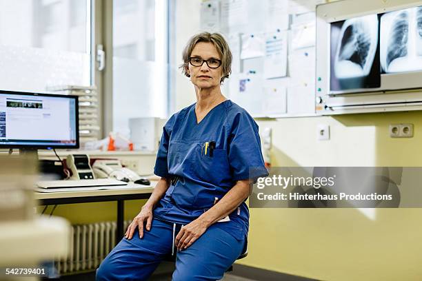 portrait of female mature doctor sitting - leanincollection healthcare stock pictures, royalty-free photos & images