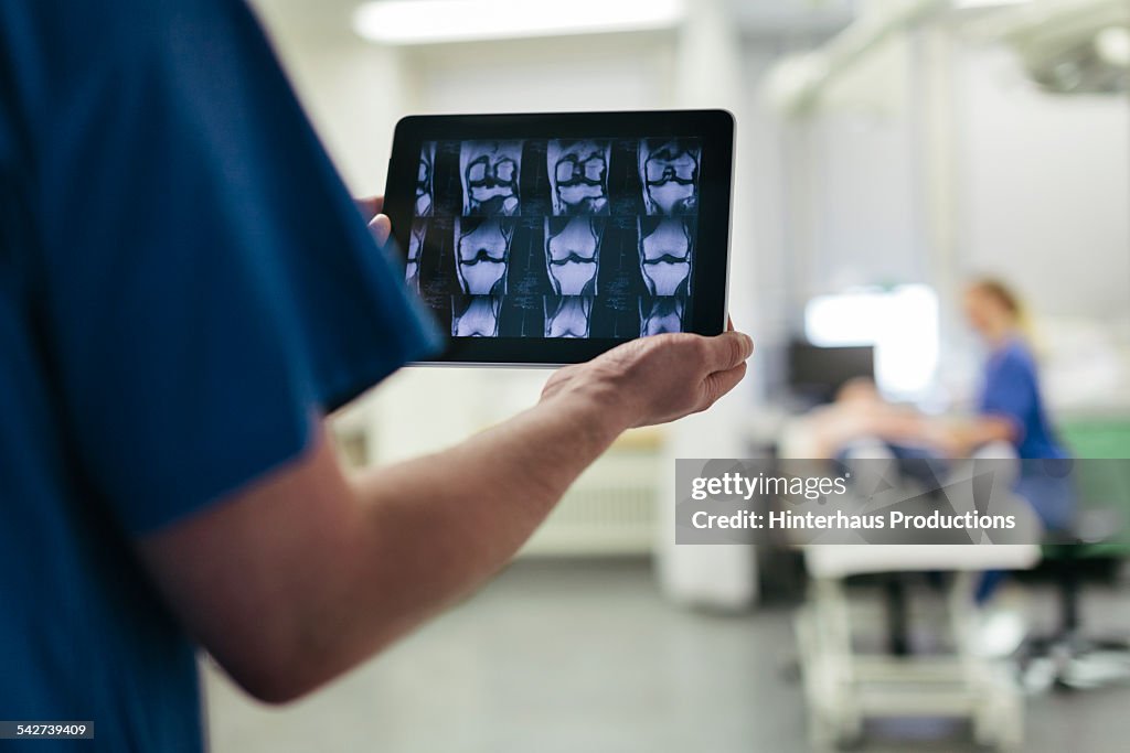 Doctor Showing MRI Images on Digital Tablet