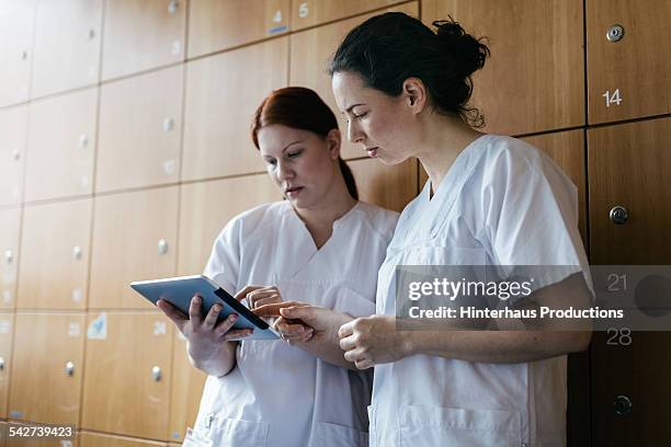 nurses with digital tablet - communication nurse stock-fotos und bilder