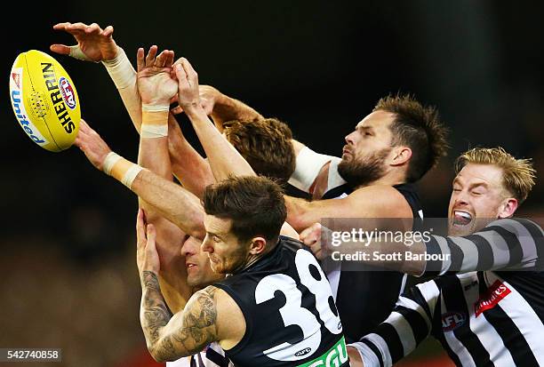 Nathan Brown of the Magpies, Jeremy Howe of the Magpies and Jonathon Marsh of the Magpies compete for the ball with Matthew Pavlich of the Dockers...