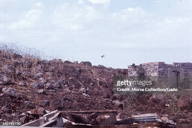 Landscape view of demolished buildings, metal and stone rubble, with dead foliage along the hillside, located outside the town of Quneitra, Syria,...
