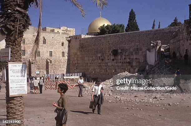 Busy street scene with Western woman reading sign warning Jews not to enter at the entrance to the Temple Mount plaza, Old City of Jerusalem, Israel,...