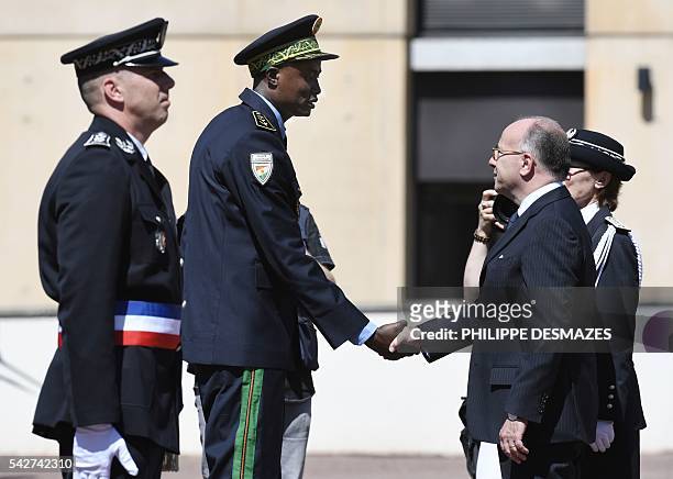 Newly promoted Nigeria's first ranked of foreign police chief shakes hand with French Interior minister Bernard Cazeneuve next to school director...