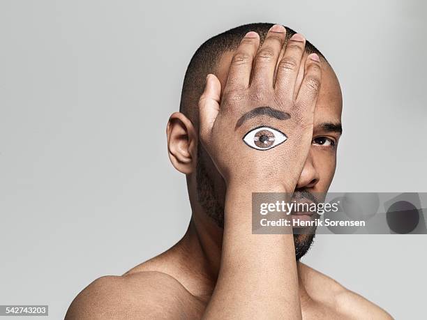 man with an eye painted on his hand - augenfarbe stock-fotos und bilder