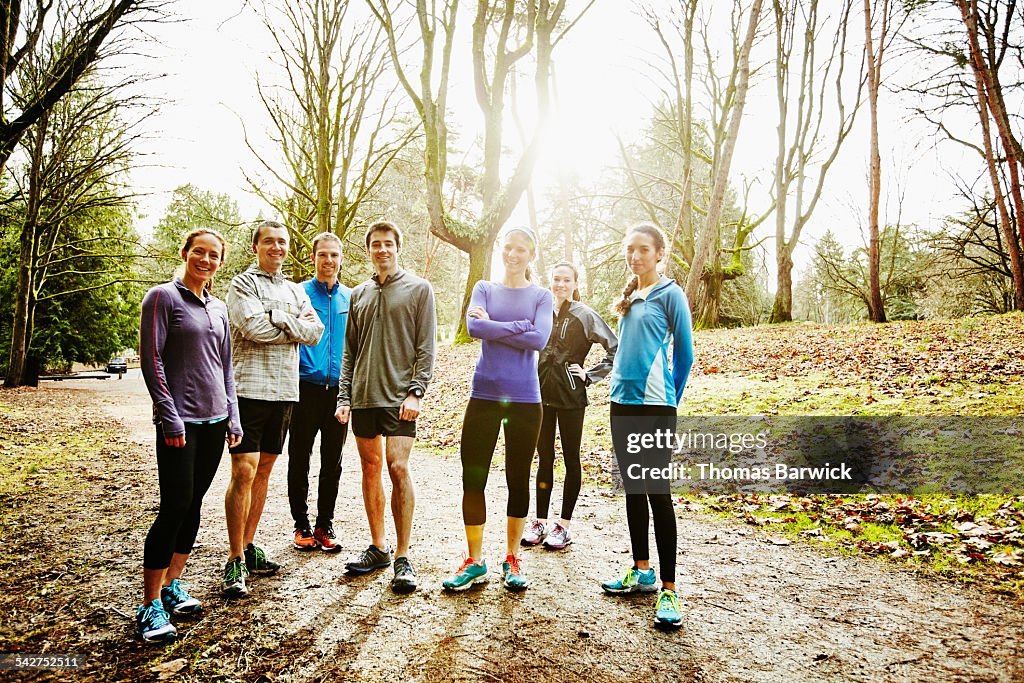 Group of runners standing together on path in park