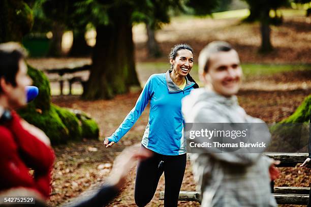 smiling female runner stretching with friends - happy morning stock pictures, royalty-free photos & images